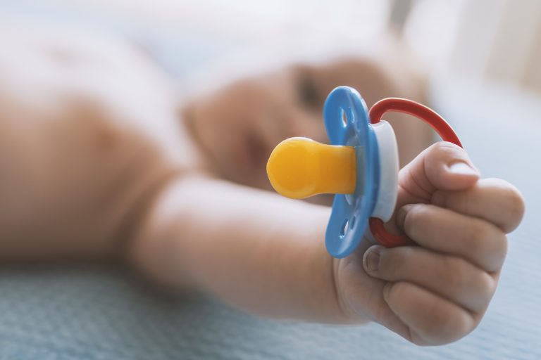 un bambino che tiene in mano il ciuccio